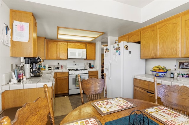 kitchen featuring white appliances and tile countertops