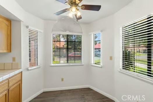 11636 Kerrie Way, Apple Valley, CA 92308 - unfurnished dining area with baseboards, dark wood-style floors, and ceiling fan