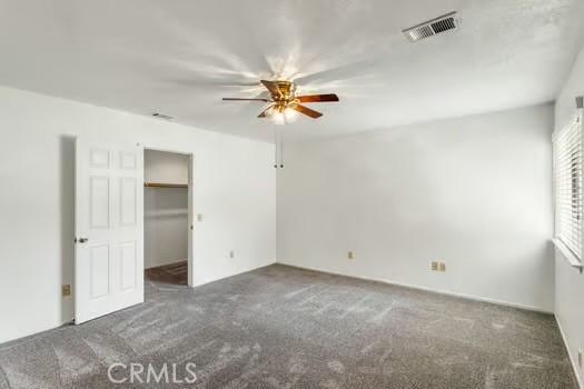 11636 Kerrie Way, Apple Valley, CA 92308 - unfurnished bedroom featuring carpet, a spacious closet, a ceiling fan, and a closet
