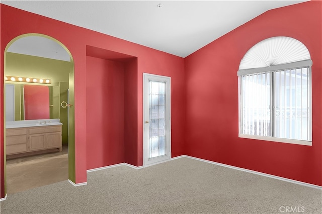 carpeted spare room with lofted ceiling