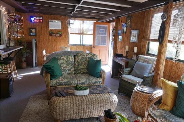 living room with dark colored carpet, beam ceiling, a wall mounted AC, and wood walls