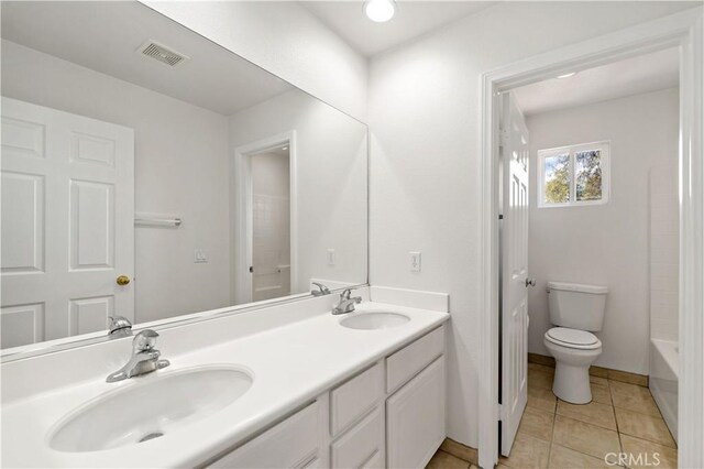 bathroom featuring vanity, tile patterned floors, and toilet