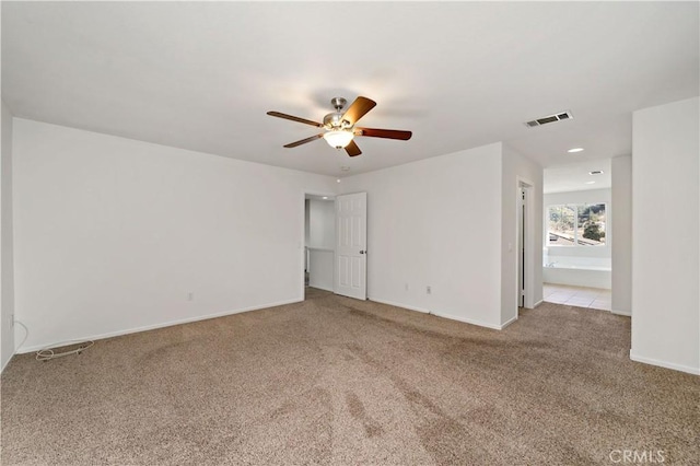 unfurnished room with light colored carpet and ceiling fan