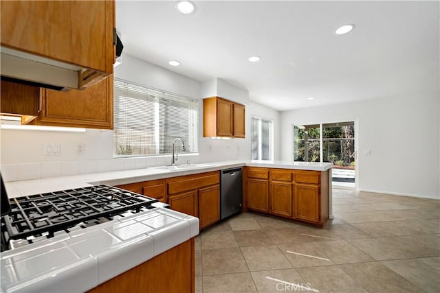 kitchen with light tile patterned flooring, dishwasher, sink, tile counters, and kitchen peninsula