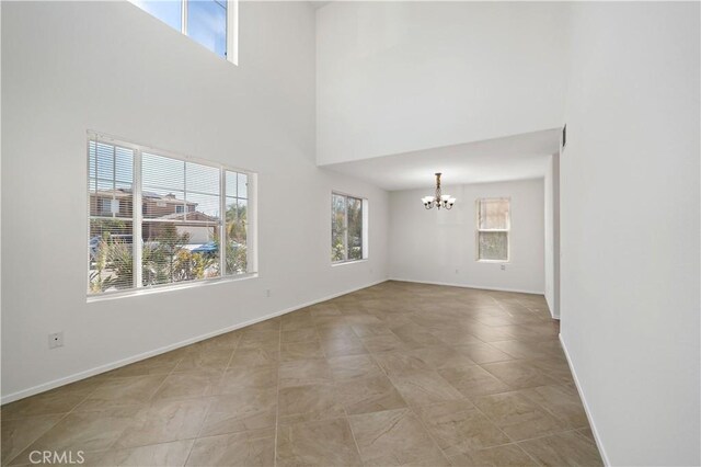 unfurnished living room featuring an inviting chandelier and a high ceiling