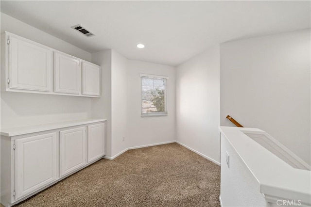 unfurnished dining area with light colored carpet