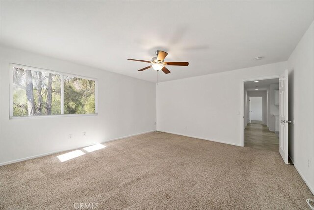 carpeted empty room featuring ceiling fan