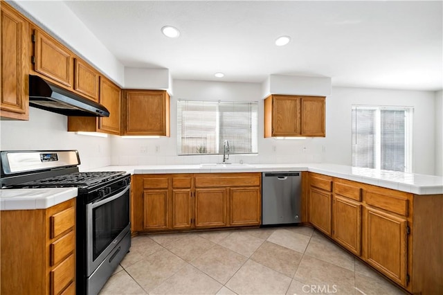 kitchen with sink, a wealth of natural light, stainless steel appliances, and kitchen peninsula