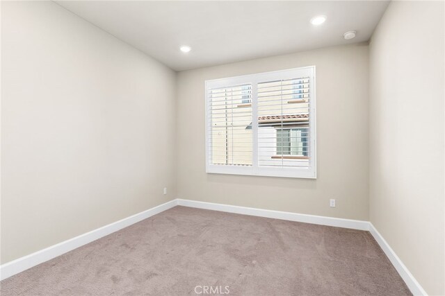 spare room featuring light colored carpet