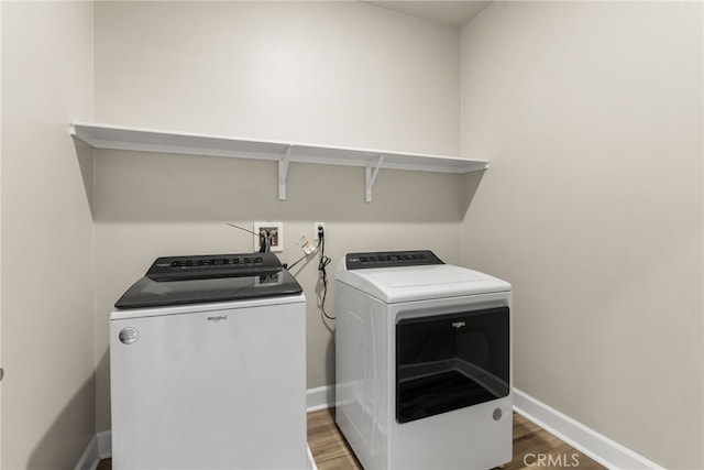 laundry area with washing machine and clothes dryer and hardwood / wood-style floors