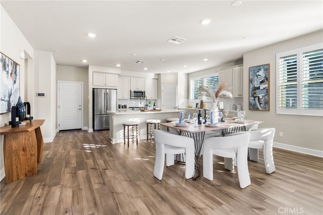 dining space with light hardwood / wood-style flooring and a healthy amount of sunlight