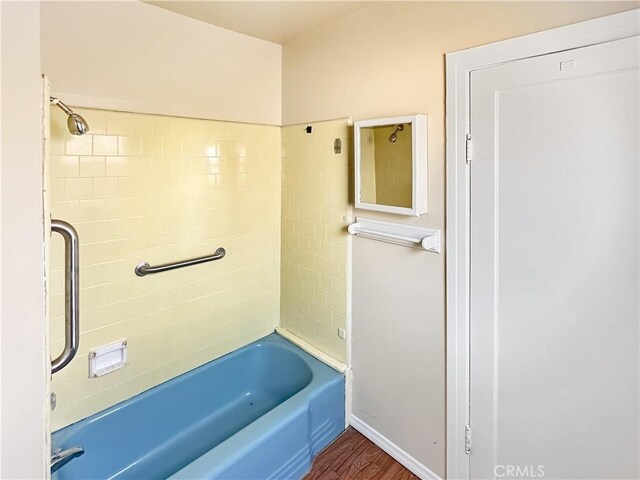 bathroom with tiled shower / bath and hardwood / wood-style flooring