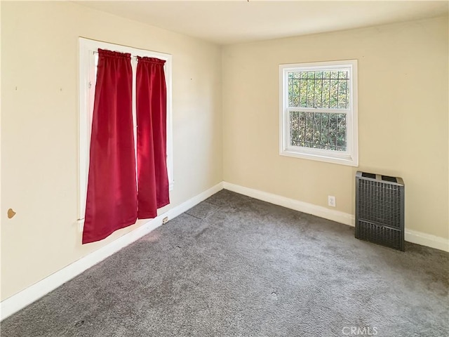 carpeted spare room featuring heating unit