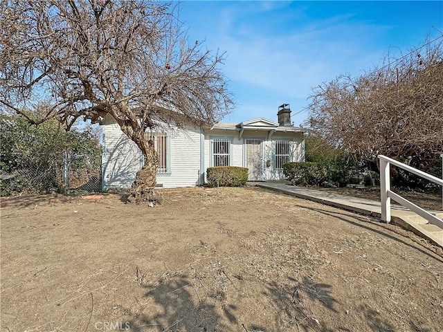 view of front of property featuring a chimney and fence