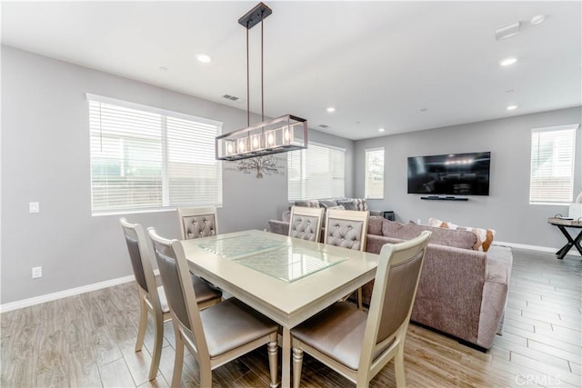 dining space featuring a notable chandelier and light hardwood / wood-style flooring