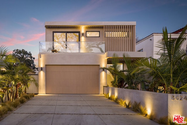 contemporary home with a garage and a balcony