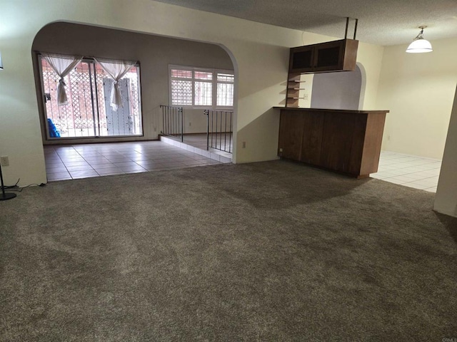 empty room featuring a textured ceiling and tile patterned flooring