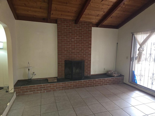 unfurnished living room with wooden ceiling, light tile patterned floors, a wealth of natural light, and lofted ceiling with beams