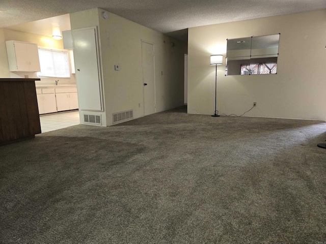 empty room with a textured ceiling and light carpet