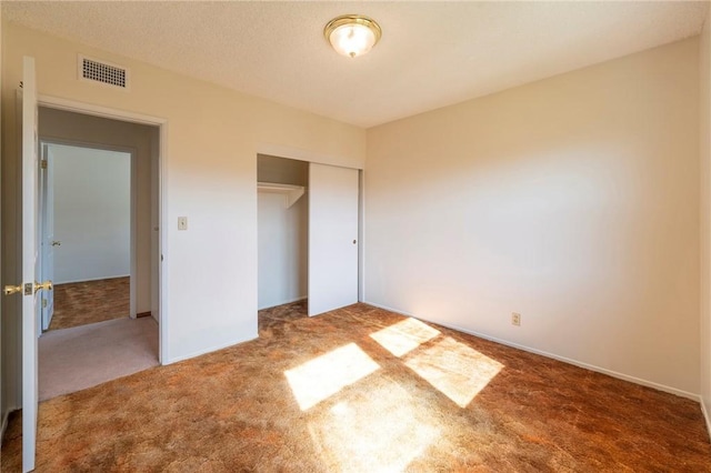 unfurnished bedroom featuring dark colored carpet and a closet