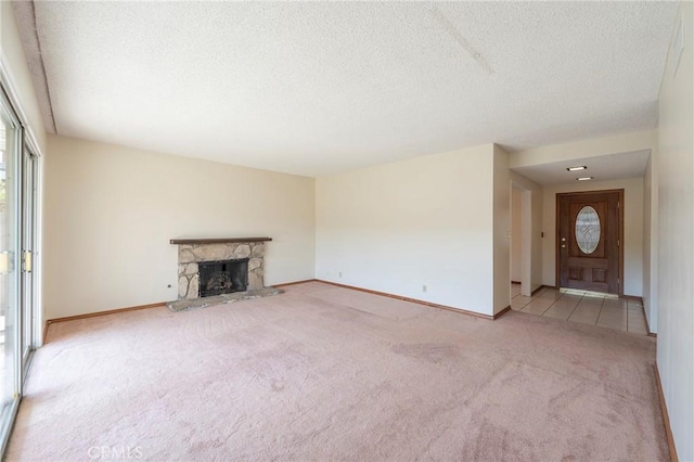 unfurnished living room with a fireplace, light carpet, and a textured ceiling