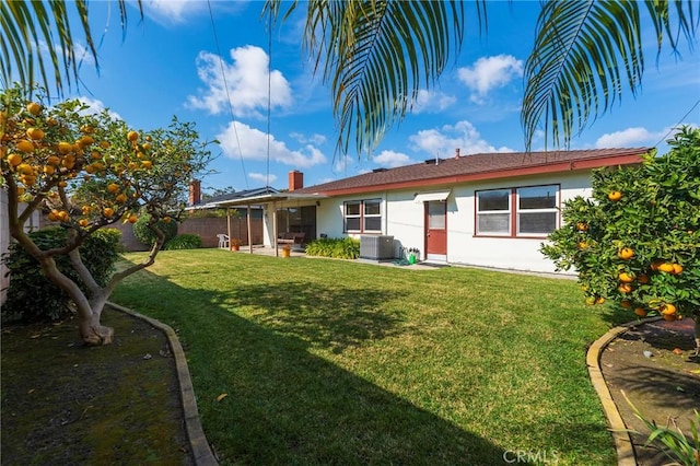 rear view of house featuring a yard, central AC, and a patio