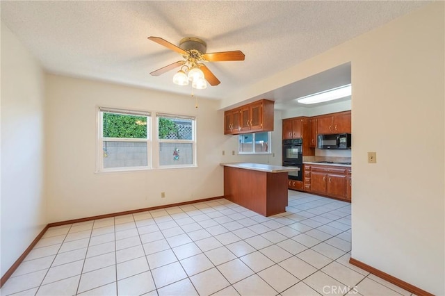 kitchen with a textured ceiling, light tile patterned floors, kitchen peninsula, ceiling fan, and black appliances