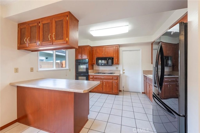 kitchen with light tile patterned flooring, kitchen peninsula, and black appliances