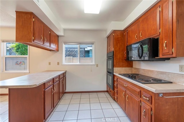 kitchen featuring kitchen peninsula, light tile patterned floors, and black appliances