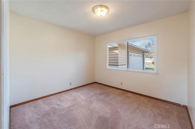 carpeted empty room featuring a textured ceiling