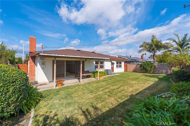 rear view of house with a patio, central AC unit, and a lawn