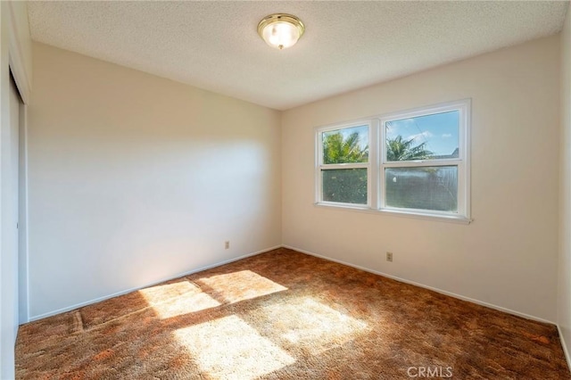 carpeted empty room featuring a textured ceiling