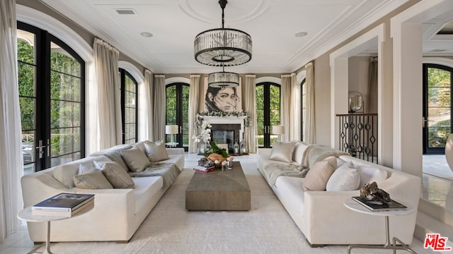 sunroom / solarium featuring plenty of natural light, french doors, and an inviting chandelier