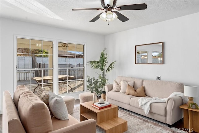 living room featuring ceiling fan, a textured ceiling, and a wealth of natural light