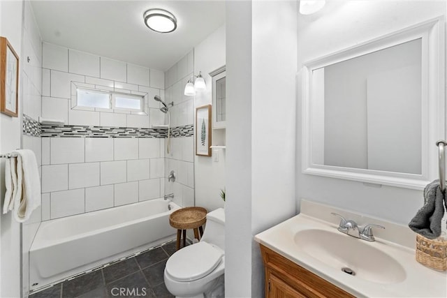 full bathroom featuring vanity, tiled shower / bath, and toilet