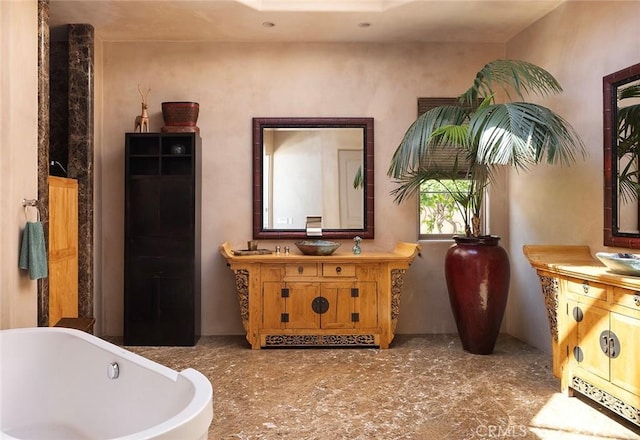 bathroom with a tub and vanity