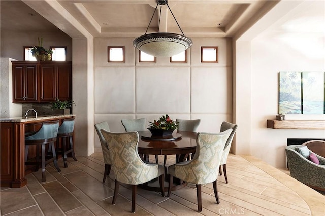 dining space with a raised ceiling