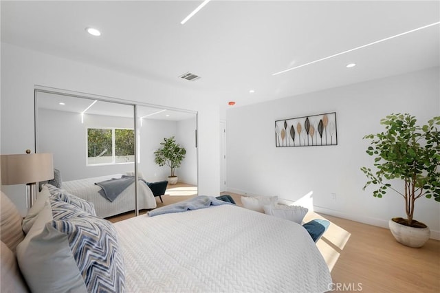 bedroom with light wood-type flooring and a closet