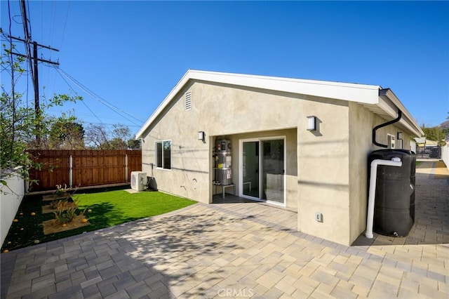 rear view of house featuring a patio area and a yard