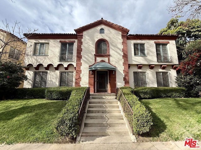 mediterranean / spanish house featuring a front lawn