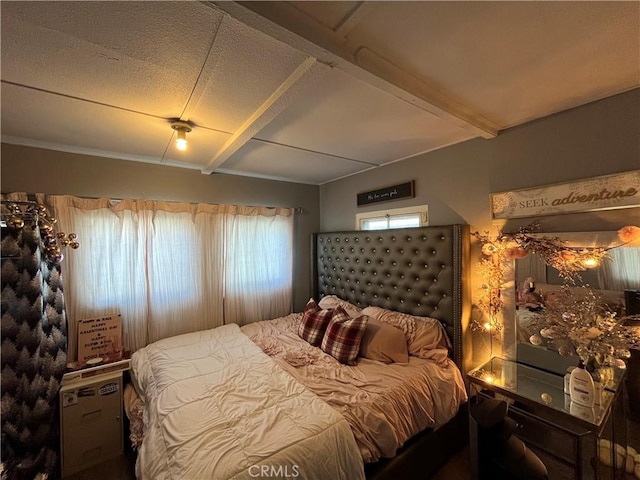 bedroom with beam ceiling and a textured ceiling