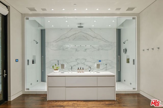 bathroom featuring a shower with shower door, tile walls, sink, and hardwood / wood-style flooring