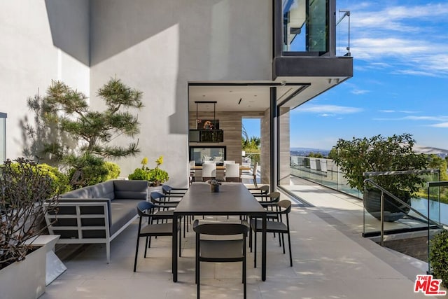 view of patio with an outdoor living space with a fireplace