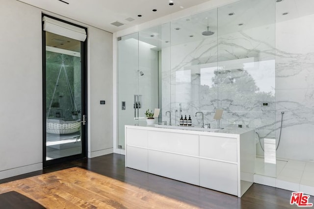 bathroom with a shower with shower door, hardwood / wood-style floors, and vanity