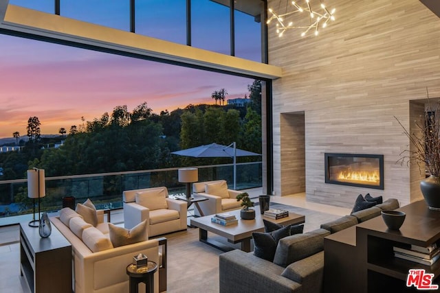 patio terrace at dusk featuring an outdoor living space with a fireplace