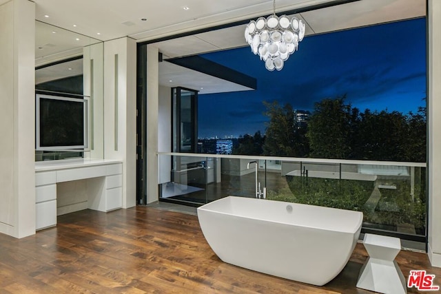 bathroom featuring a tub to relax in, expansive windows, a chandelier, and hardwood / wood-style floors