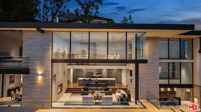 back house at dusk with outdoor lounge area