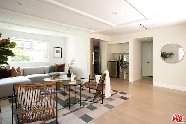 living room with light wood-type flooring and separate washer and dryer