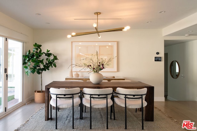 dining area featuring wood-type flooring and a chandelier