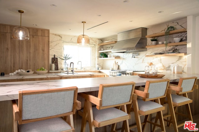 kitchen featuring exhaust hood, stove, a kitchen bar, and sink